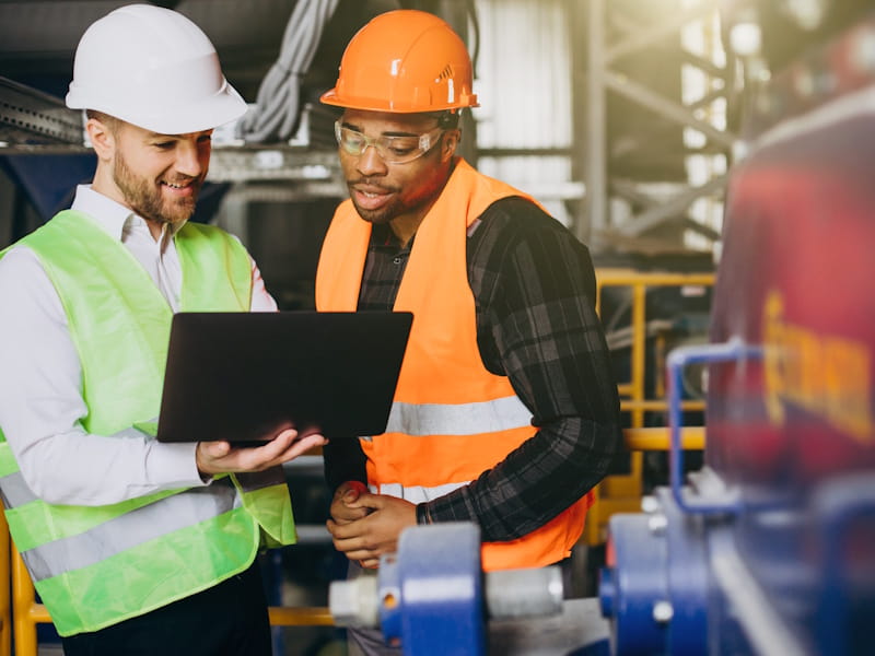 two site workers inspecting analytics on a computer